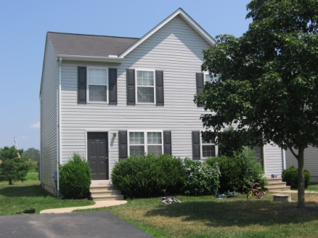 two story townhouse duplex light grey siding with dark grey front door