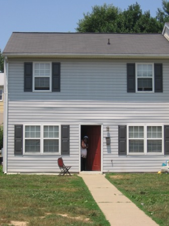 grey two story townhouse with red front door